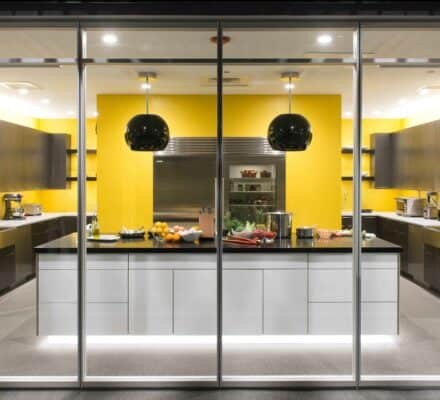 Yellow painted kitchen with brown cabinets displaying a prep station countertop with food ingredients