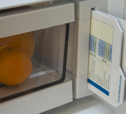 A refrigerator drawer with oranges inside, featuring a slide-out reference card labeled "FOOD PRESERVATION" and "USE AND CARE" on the side—an elegant touch for any luxury kitchen appliance or kitchen showroom display.