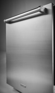 A stainless steel Cove dishwasher with a horizontal handle and the Cove logo on the front, photographed from a side angle, showcases the sleek design typical of Cove appliances.