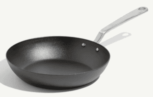 A black carbon steel frying pan, perfect for any cooktop, features a sleek silver metal handle and is displayed against a plain white background.