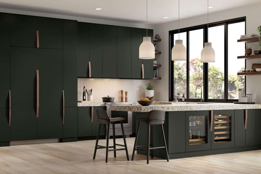 Modern kitchen with dark green cabinets, light countertops, a built-in beverage refrigerator, two black barstools, pendant lights, and large windows overlooking a garden.
