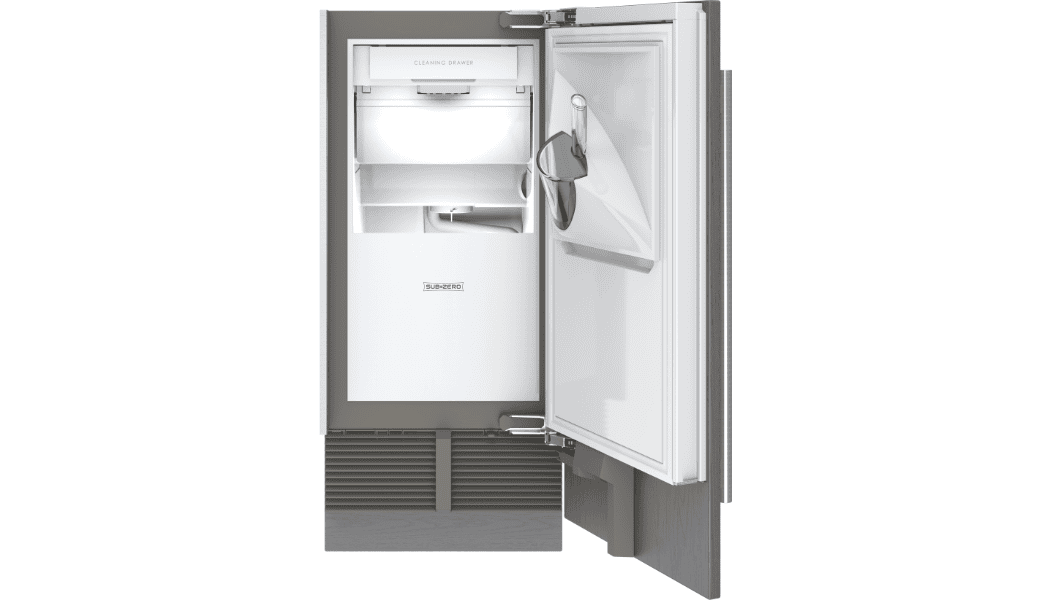A built-in ice maker with the door open, showing the ice compartment, ice scoop, and interior shelves.